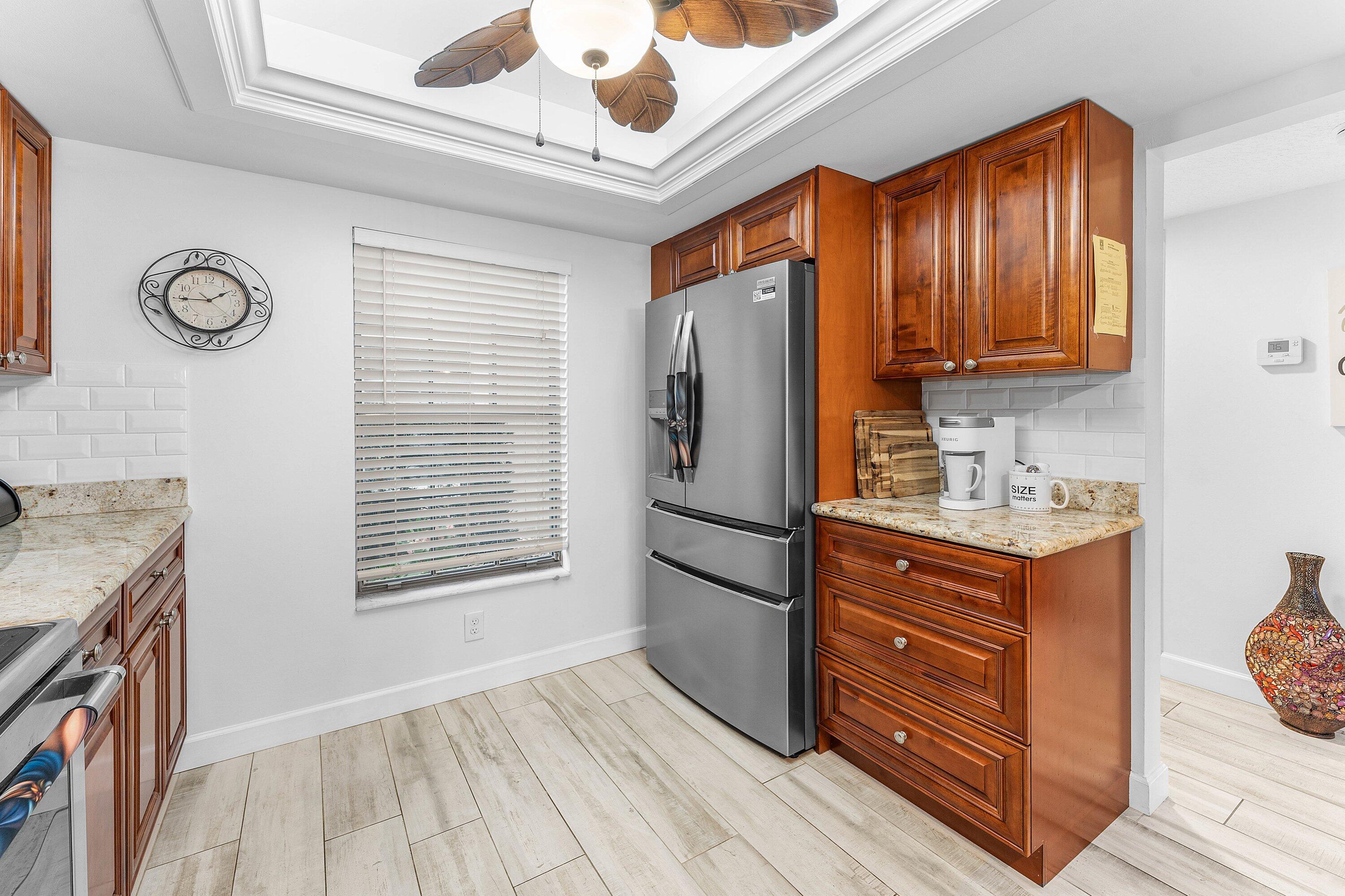 9179 Southeast Riverfront Terrace, Unit F Jupiter, FL 33469 - Photo 5 of 50 a kitchen with stainless steel appliances granite countertop a stove a refrigerator and a sink with large cabinets