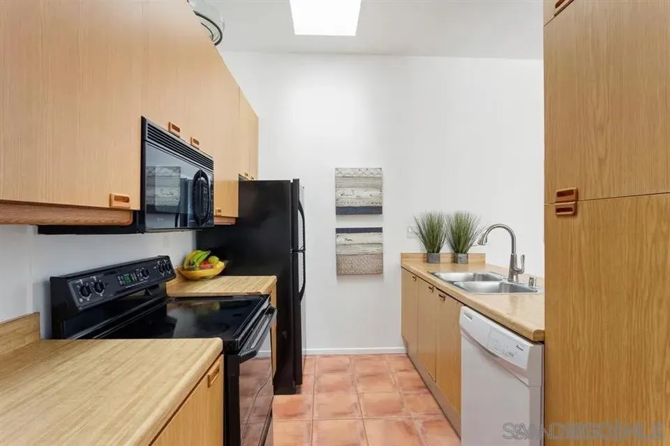 8328 Regents Road, Unit 3G San Diego, CA 92122 - Photo 5 of 8 a kitchen with stainless steel appliances a stove refrigerator sink and cabinets