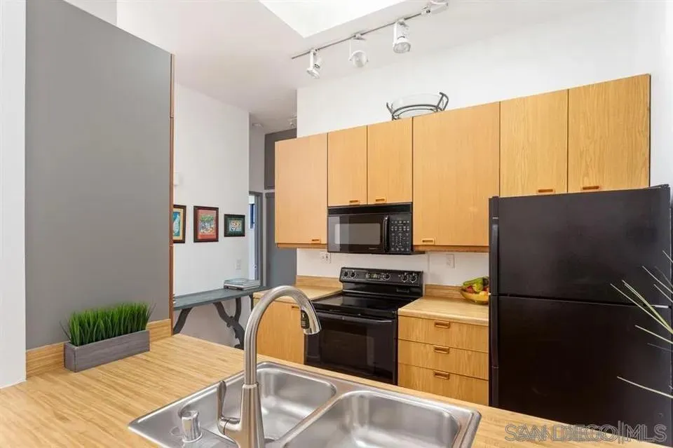 8328 Regents Road, Unit 3G San Diego, CA 92122 - Photo 6 of 8 a kitchen with a refrigerator and a stove top oven