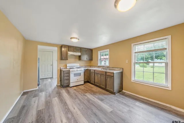 a kitchen with wooden floors and white appliances