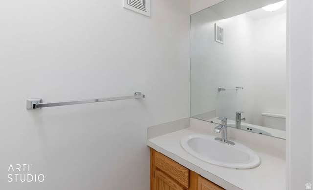 4823 Old Post Road Ogden, UT 84403 - Photo 10 of 19 Vanity with wood-finish cabinetry, integrated sink, chrome faucet, and expansive mirror