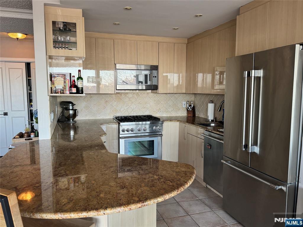 4 Horizon Road, Unit G20 Fort Lee, NJ 07024 - Photo 6 of 13 a kitchen with stainless steel appliances granite countertop a refrigerator a stove and a sink