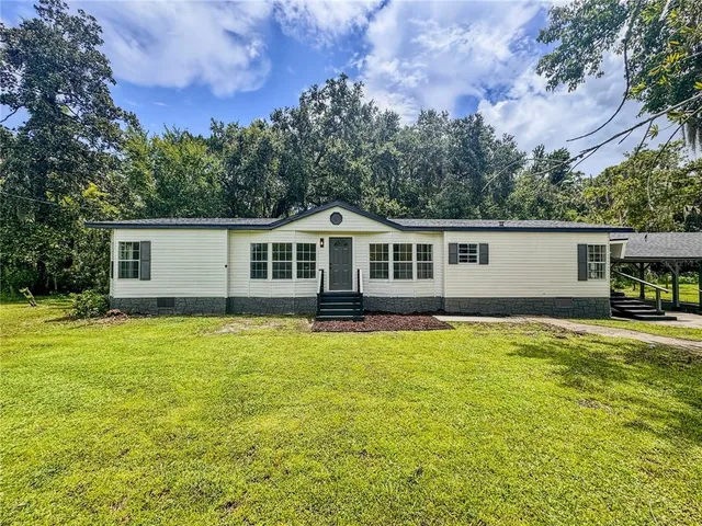 a backyard of a house with table and chairs