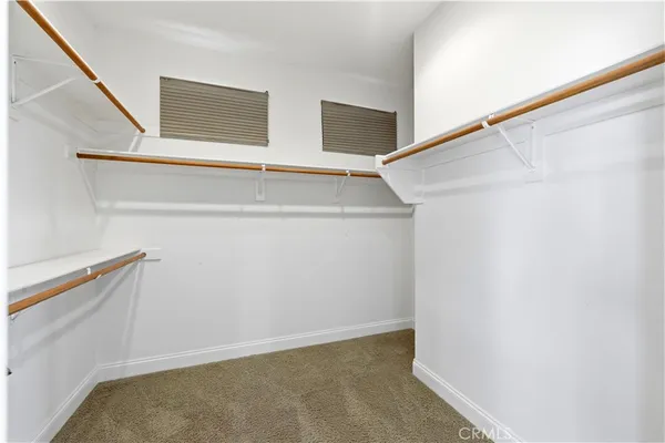an empty room with closet and a ceiling fan