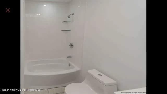 a white toilet sitting next to a bath tub