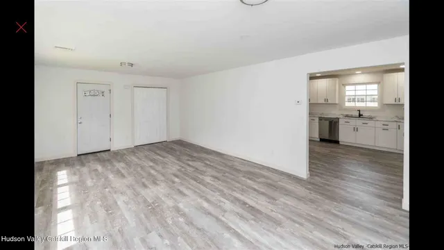 a view of a kitchen with a sink and dishwasher a refrigerator with wooden floor