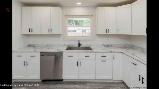a kitchen with granite countertop white cabinets and sink