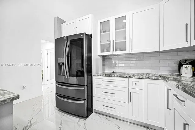 a kitchen with granite countertop white cabinets stainless steel appliances and sink