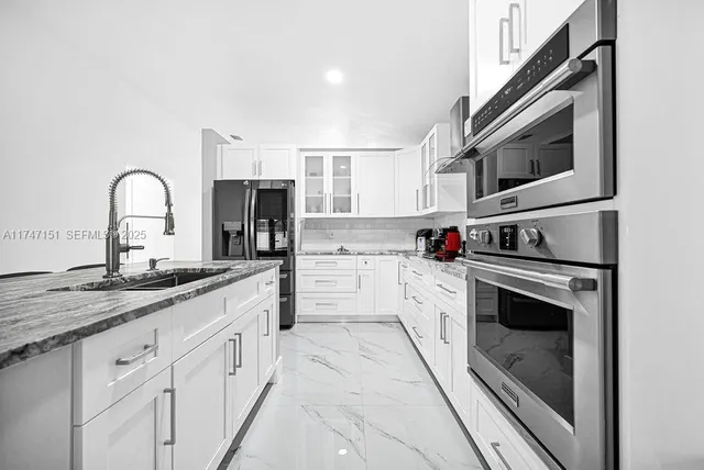 a kitchen with a stove a sink and a refrigerator