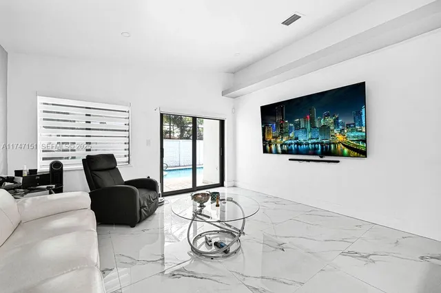 a living room with furniture a large window and a flat screen tv
