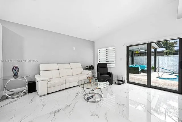 a living room with furniture and kitchen view