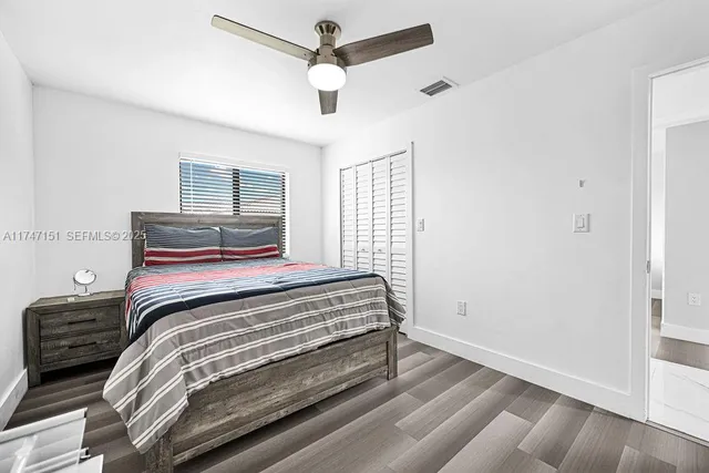 a bedroom with a bed a chandelier and a television