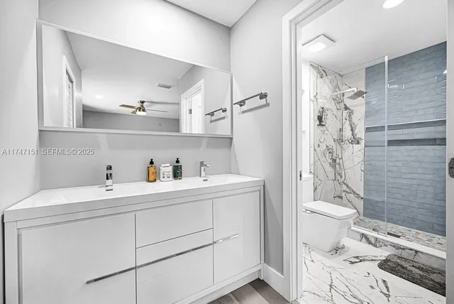 a bathroom with a sink a toilet and shower