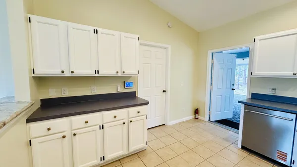 a kitchen with granite countertop white cabinets and stainless steel appliances