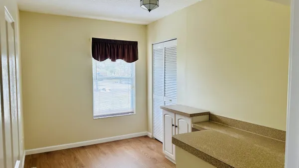 an empty room with wooden floor and a ceiling fan