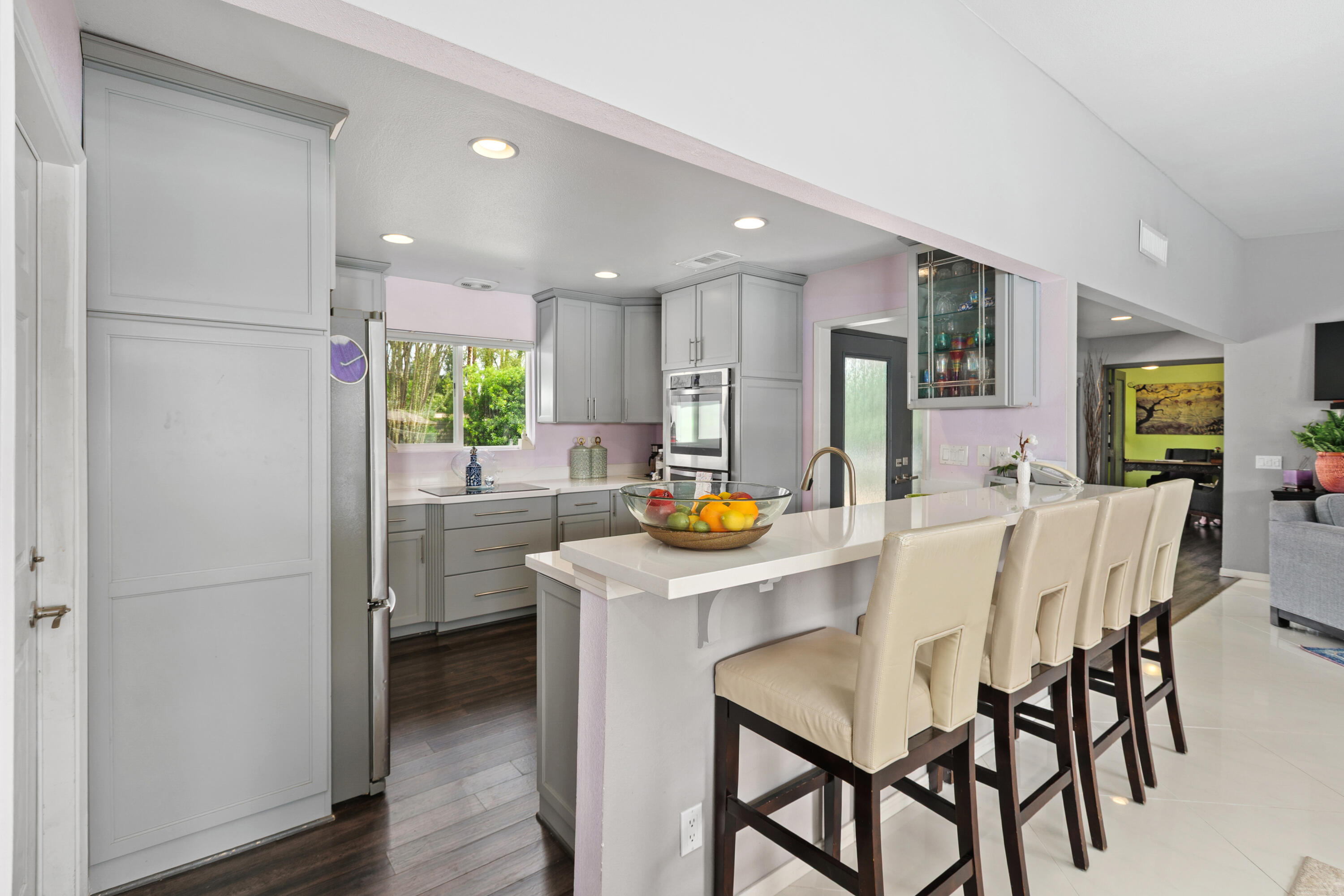 71305 Kempton Avenue Rancho Mirage, CA 92270 - Photo 21 of 58 a kitchen with stainless steel appliances a dining table chairs refrigerator and sink