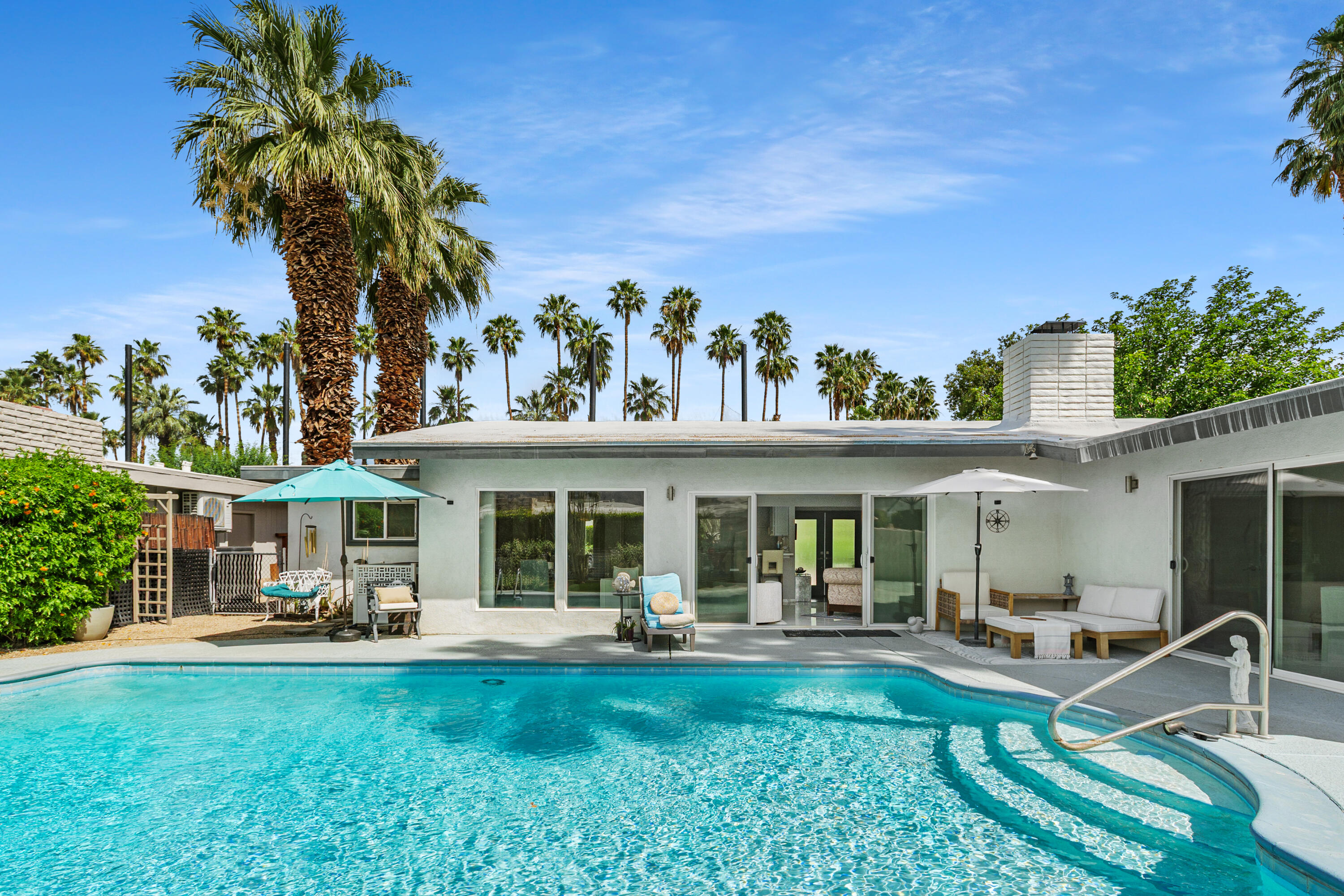 71305 Kempton Avenue Rancho Mirage, CA 92270 - Photo 41 of 58 a view of a house with a swimming pool and a chairs