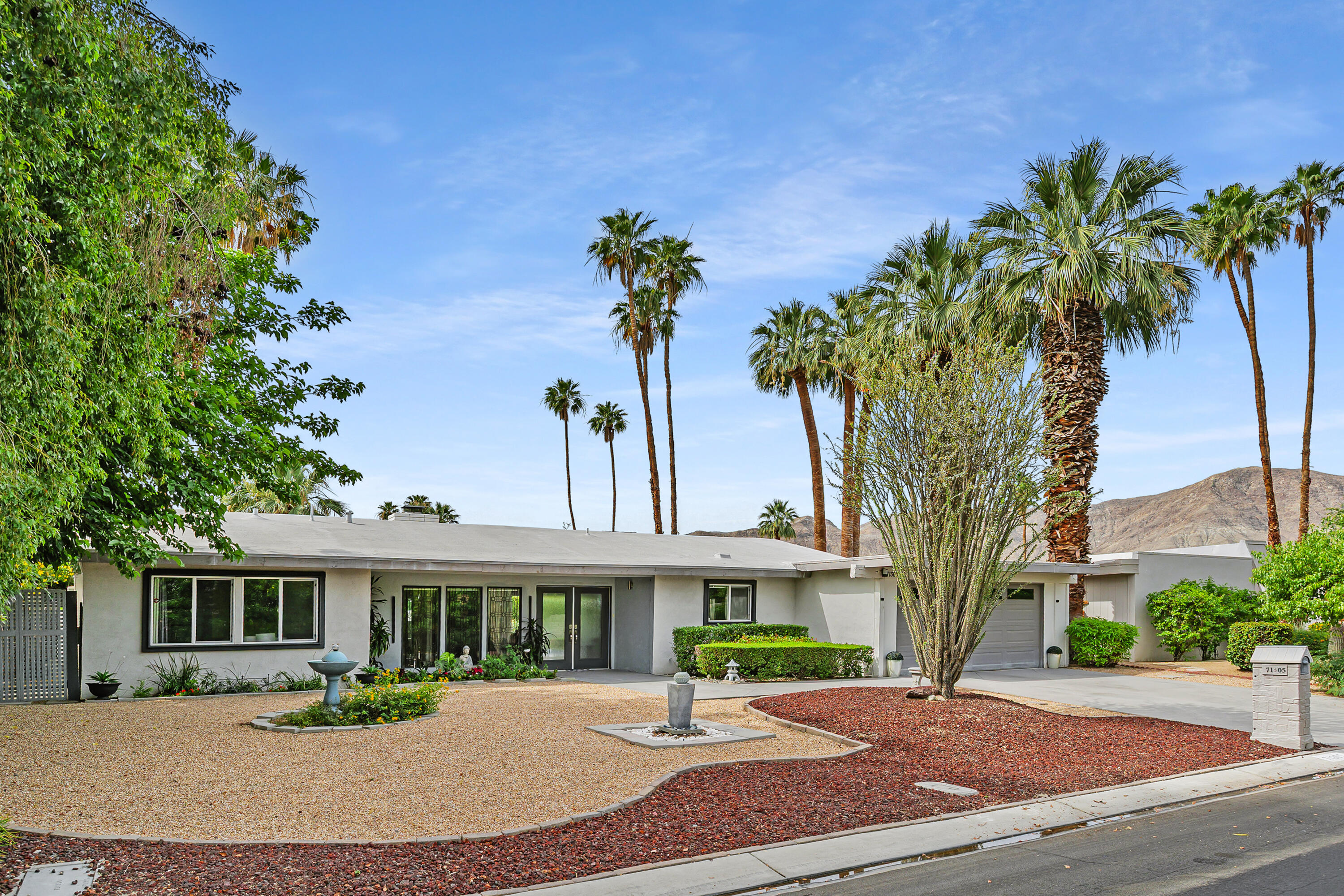 71305 Kempton Avenue Rancho Mirage, CA 92270 - Photo 50 of 58 a front view of a house with a yard and potted plants