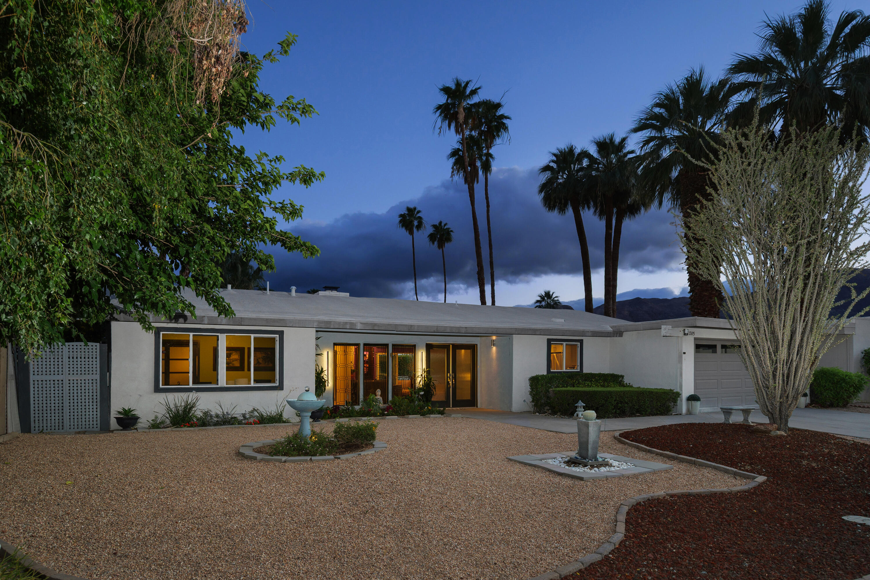 71305 Kempton Avenue Rancho Mirage, CA 92270 - Photo 8 of 58 a front view of a house with a garden and tree