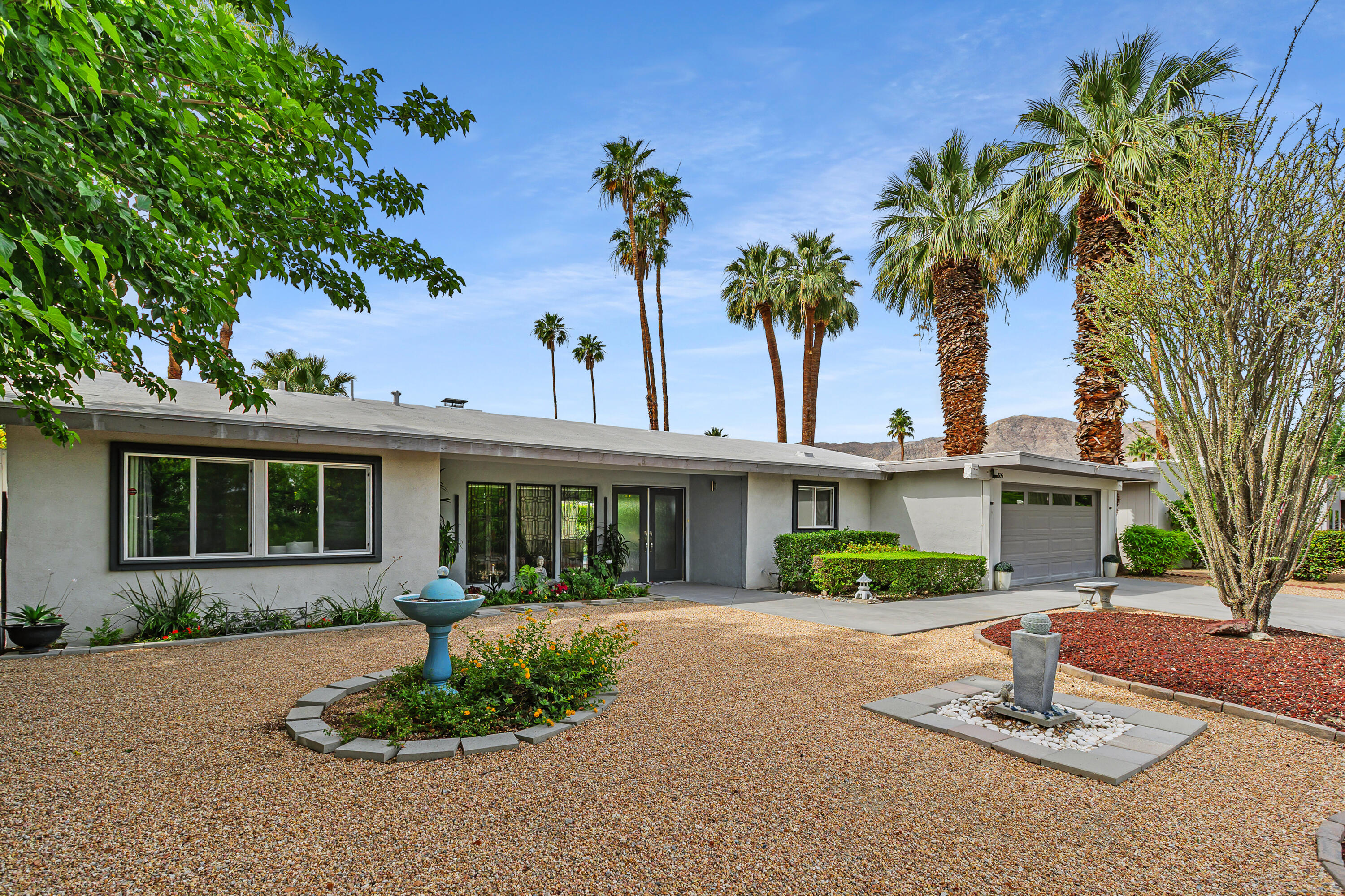 71305 Kempton Avenue Rancho Mirage, CA 92270 - Photo 9 of 58 a front view of a house with a garden and tree