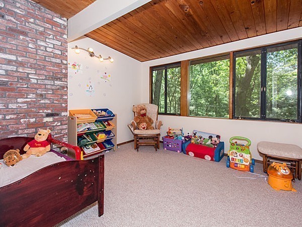 138 Weston Road Lincoln, MA 01773 - Photo 17 of 22 a living room filled with furniture and a baby crib