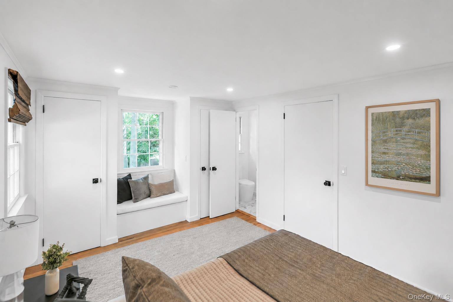 275 Pinewood Road Cutchogue, NY 11935 - Photo 26 of 45 Window seat with integrated storage, wood-finish flooring, recessed lighting, white interior doors with dark hardware, and a window with natural light