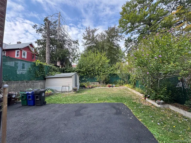 a pathway of a house with a yard and sitting area