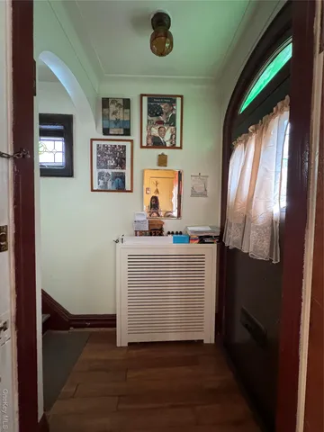 a view of hallway with window and wooden floor