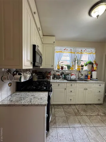 a kitchen with a sink a stove and cabinets