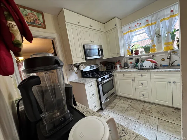 a kitchen with a appliances a sink and a stove
