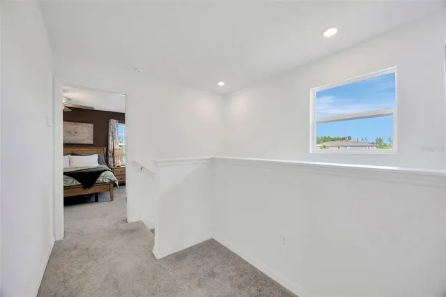 a spacious bedroom with a bed a couch and a flat tv screen on the dresser