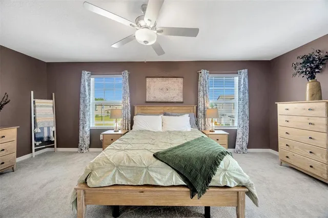 a spacious bedroom with a large bed and a chandelier