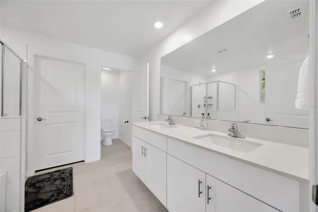 a bathroom with a double vanity sink mirror and shower