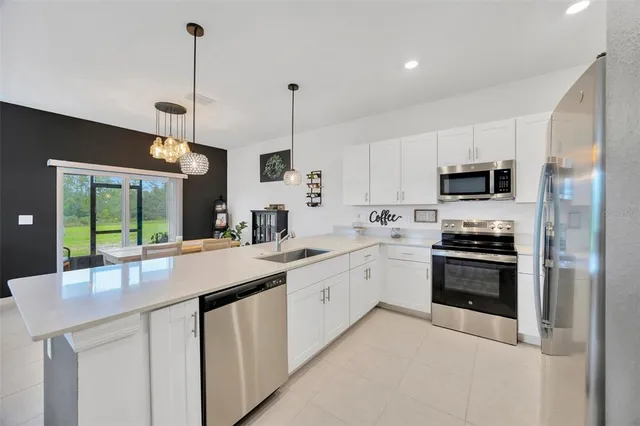 a kitchen with stainless steel appliances granite countertop a sink a stove and a wooden floors