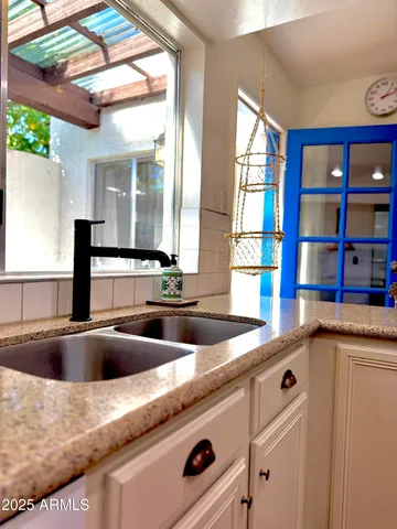 a kitchen with stainless steel appliances granite countertop a stove a sink and a dining table chair