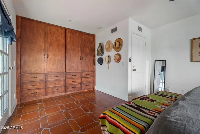 a bedroom with a bed and a painting on the wall