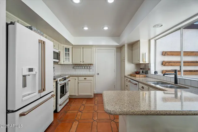 a living room with table chairs and a chandelier