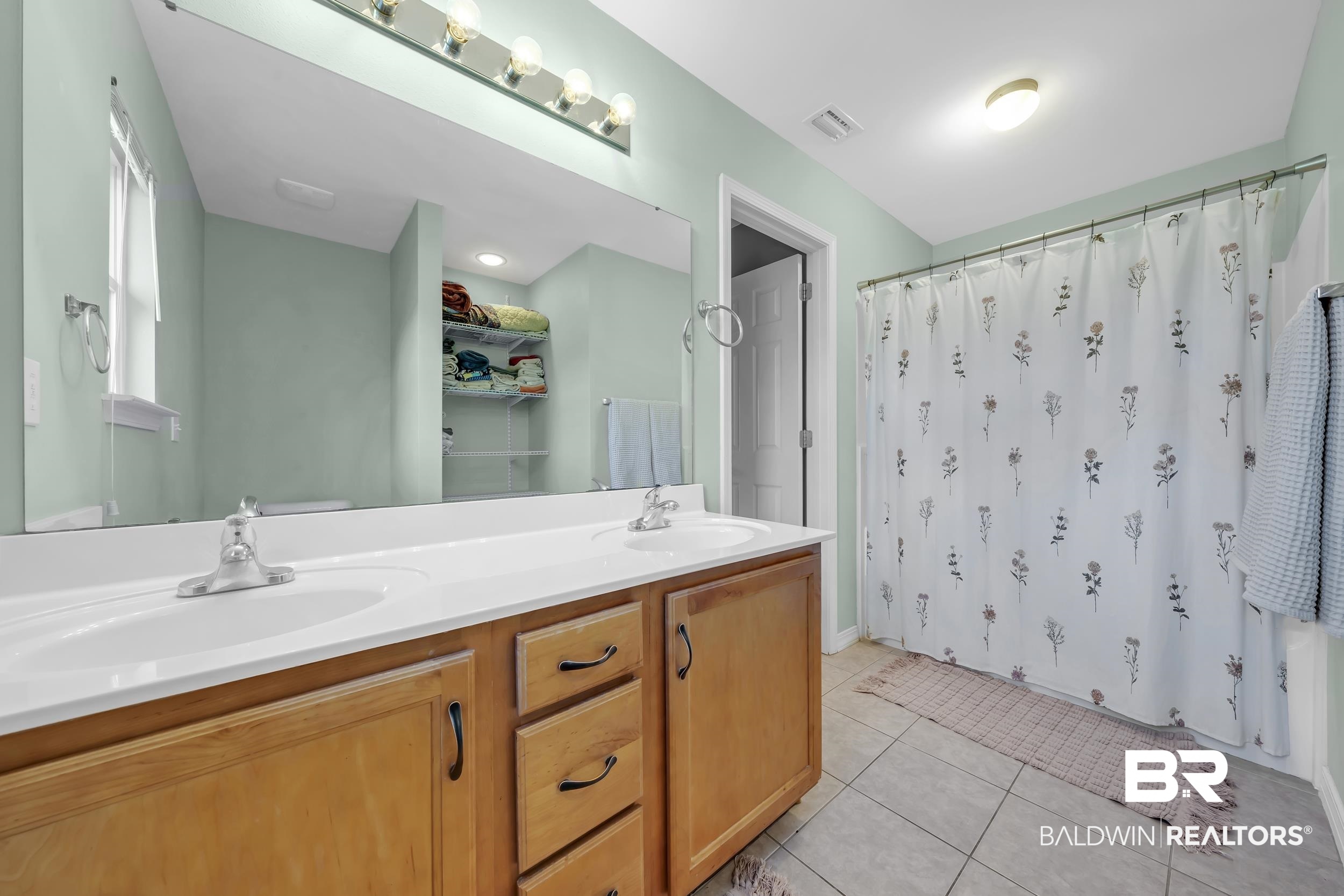 31527 Heidelbrook Loop Daphne, AL 36527 - Photo 13 of 22 Bathroom with double vanity, light tile patterned flooring, and shower / tub combo