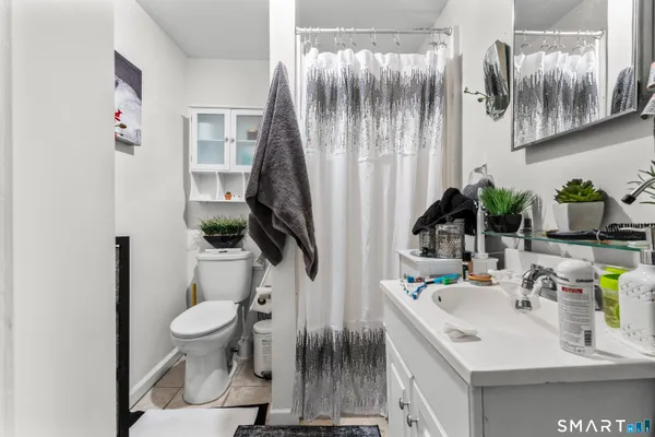 a bathroom with a sink toilet a mirror and shower