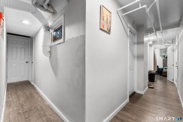 a view of a hallway with wooden floor and staircase