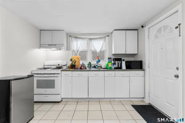 a kitchen with white cabinets and appliances