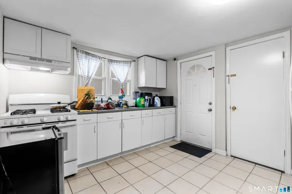 a kitchen with white cabinets and appliances