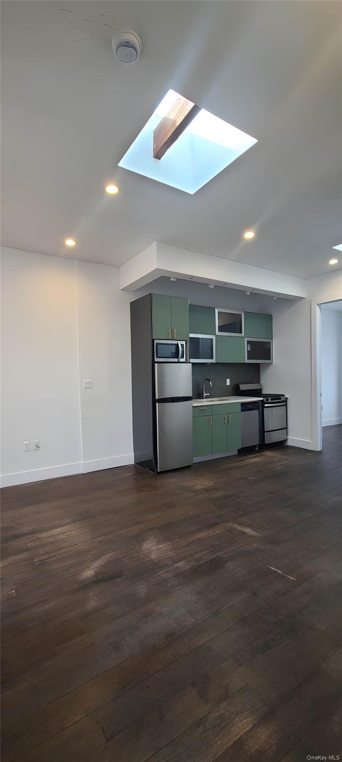 548 Howard Avenue, Unit 2L Brooklyn, NY 11233 - Photo 1 of 7 an empty room with wooden floor and a kitchen