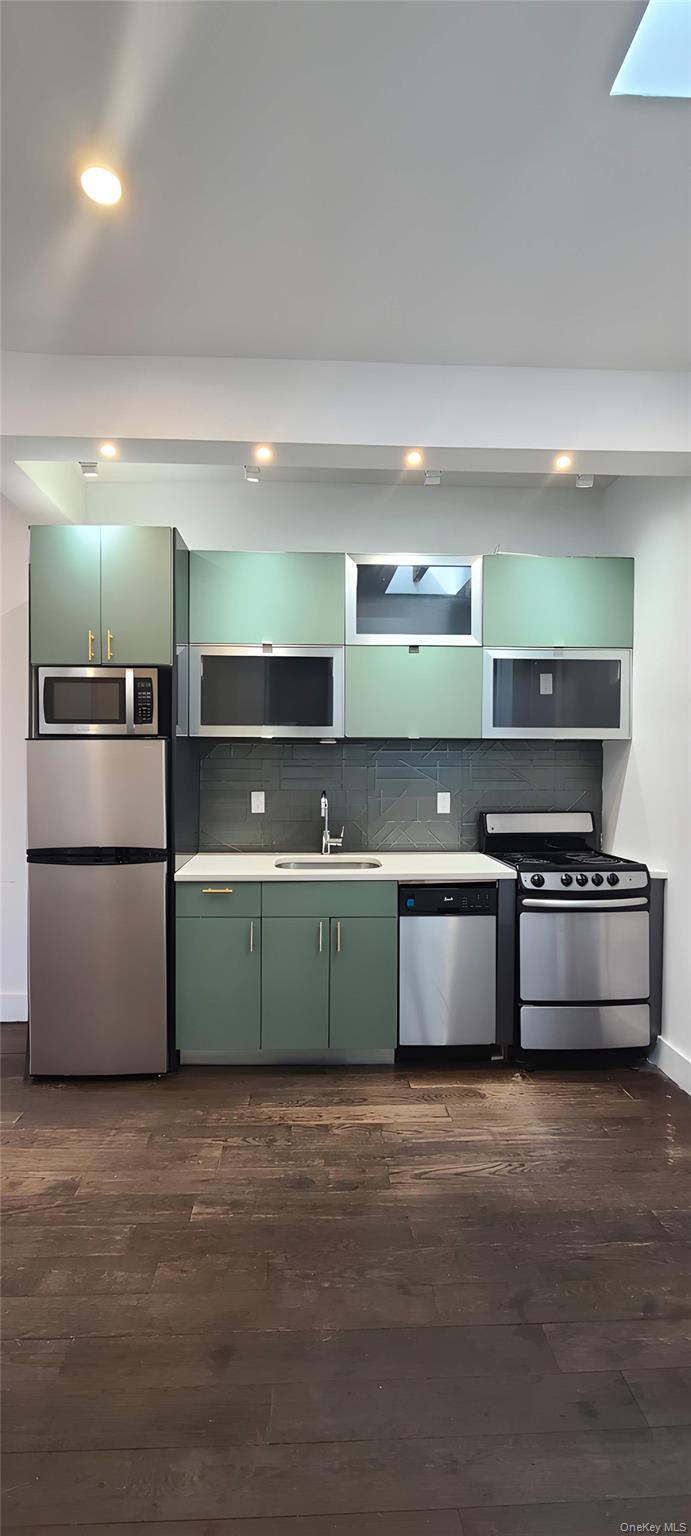 548 Howard Avenue, Unit 2L Brooklyn, NY 11233 - Photo 3 of 7 a kitchen with stainless steel appliances and a wooden floor