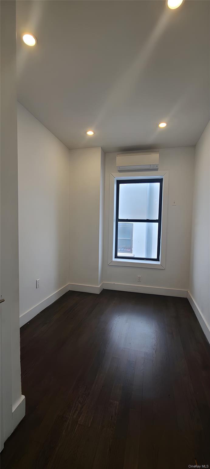 548 Howard Avenue, Unit 2L Brooklyn, NY 11233 - Photo 6 of 7 an empty room with wooden floor and windows