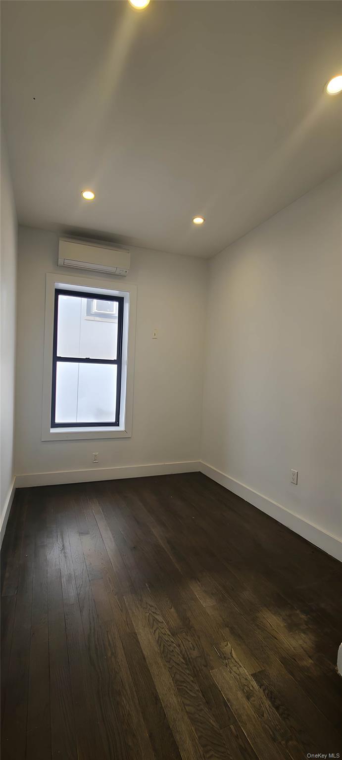 548 Howard Avenue, Unit 2L Brooklyn, NY 11233 - Photo 7 of 7 an empty room with wooden floor and windows
