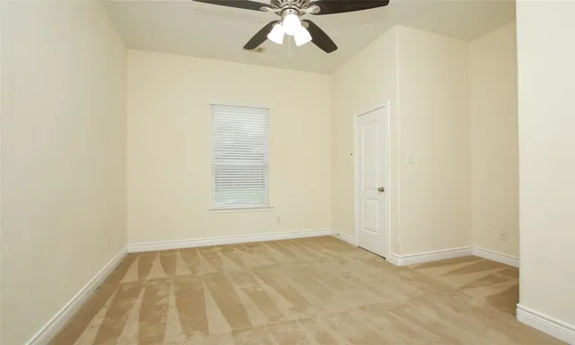 an empty room with a ceiling fan and wooden floor