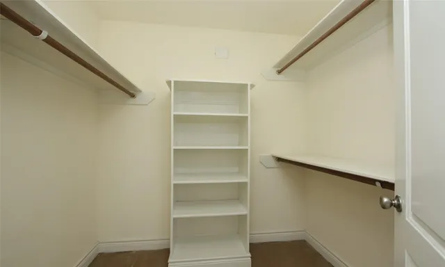 a view of walk in closet with empty racks