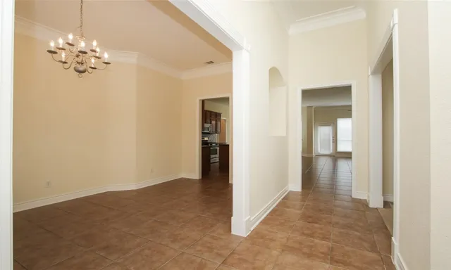 a view of a hallway with wooden floor and chandelier