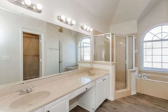 a bathroom with a sink double vanity granite tub and a mirror